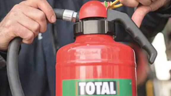 Close-up of a fire extinguisher as someone pulls out its pin