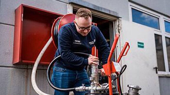 Firefighter inspecting a water hose