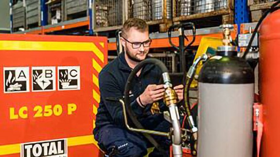 Firefighter inspecting a fire extinguisher