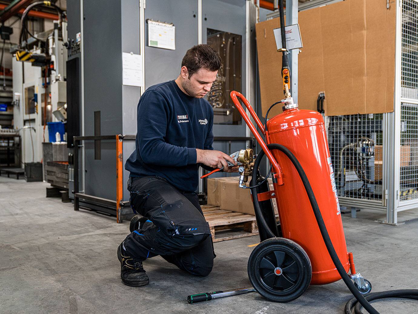 Firefighter inspecting a fire extinguisher