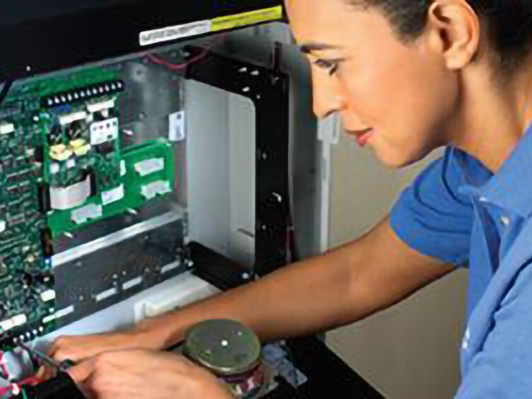 Female technician inspecting a motherboard of a device