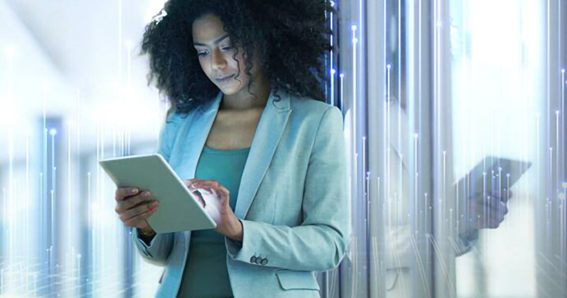Young businesswoman working on a tablet with graphics of transmission nodes in the background