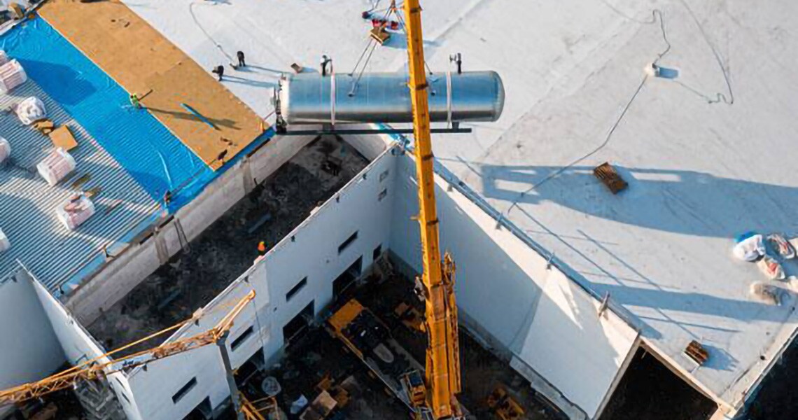 Aerial view of a crane installing a tanker in an outdoor space