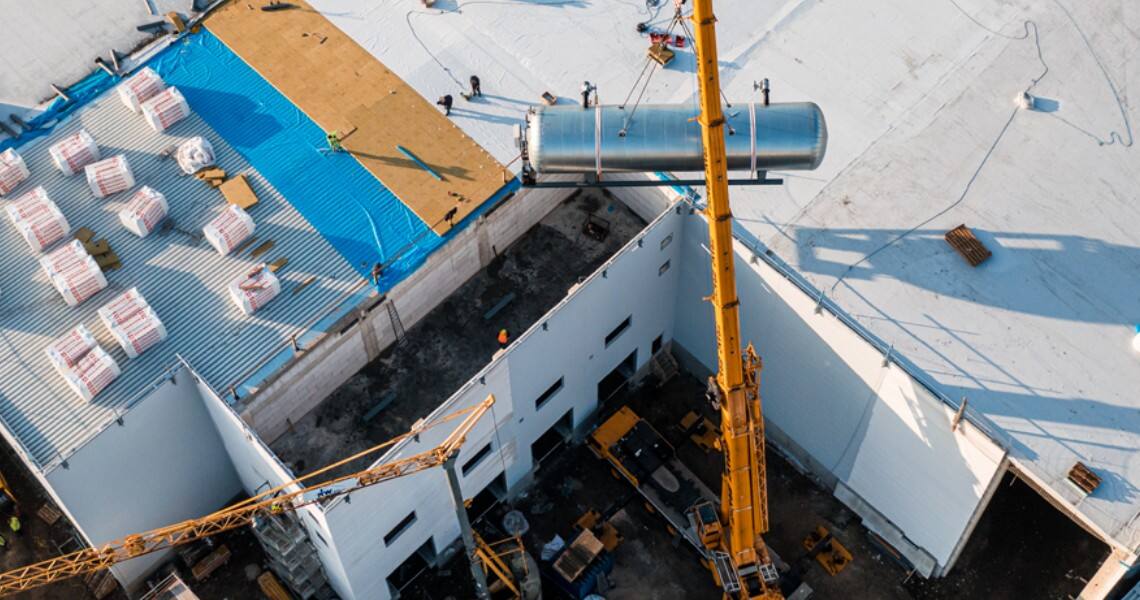 Aerial view of a crane installing a tanker in an outdoor space