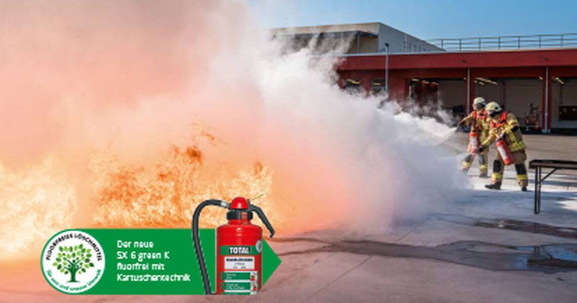 A Total fire extinguisher overlaid on an image of a group of firefighters in uniform dousing a flame