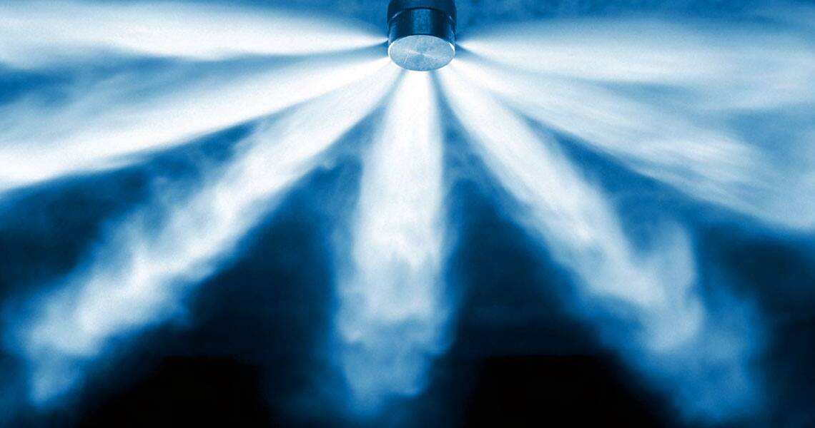 Water spraying from a fire sprinkler in close-up