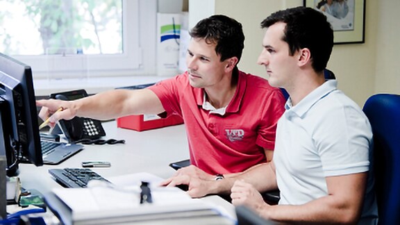 Two man discussing looking on the monitor