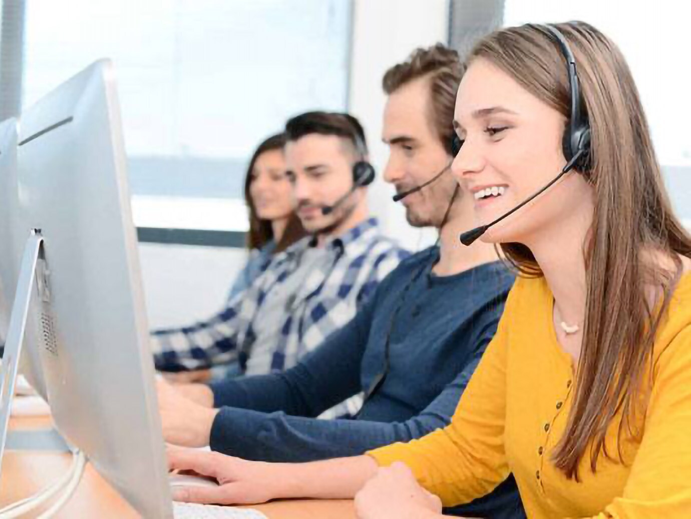 Group of service hotline employees working while wearing a headset