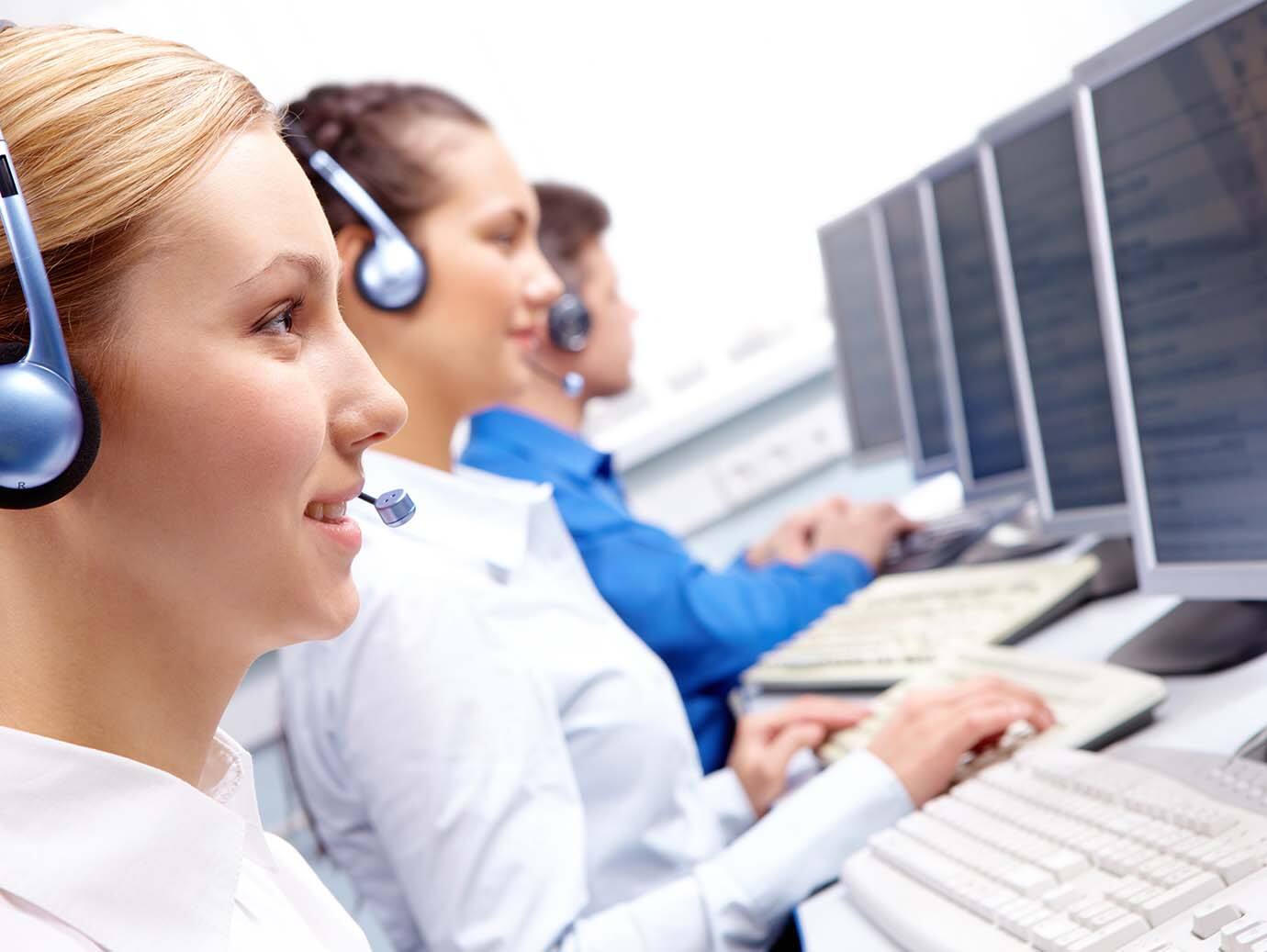 Group of service hotline employees working while wearing a headset