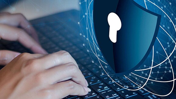 Close-up of a person typing on a keypad with the security icon